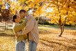 © BGStock72 - Joyful couple enjoying a sunny autumn day in a park surrounded by colorful leaves