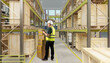 © Grispb - Warehouse, logistics center. Warehouse worker checks stacked parcels with a handheld device, verifying inventory records, storage placement, and order preparation among industrial racks.