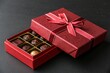 © Anastasiia Kasina - Red box of chocolate gift with ribbon isolated on black background