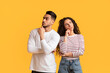 © Prostock-studio - Thoughtful Arab Young Man And Woman Standing Over Yellow Studio Background, Middle Eastern Millennial Male And Female Touching Chin And Looking Away, Thinking And Considering Options, Copy Space