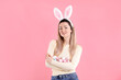 © New Africa - Easter celebration. Portrait of smiling woman in headband with bunny ears holding painted eggs on pink background, space for text