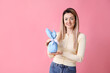 © New Africa - Easter celebration. Smiling woman holding wrapped gift on pink background, space for text