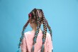 © New Africa - Cute girl with stylish braids on light blue background, back view
