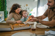 © Miljan Živković - Family enjoying pizza dinner together in domestic kitchen