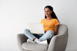 © Prostock-studio - Freelance Concept. Portrait Of Young Woman Sitting In Armchair With Laptop, Working Or Study Remotely At Home, Smiling Millennial Female Enjoying Distance Learning Or Online Job, Copy Space