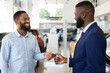 © Prostock-studio - Car Leasing Concept. Friendly Black Manager In Suit Handing Keys To Male Customer In Auto Showroom, Young African American Man Buying Or Renting New Automobile In Modern Dealership Center