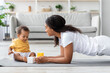 © Prostock-studio - Healthy Lifestyle Concept. Young Black Mother Training At Home With Cute Little Baby Playing Around, Beautiful African American Woman Doing Plank Exercise And Looking At Her Adorable Infant Child
