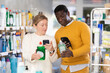© JackF - Couple adult man and woman buyers scanning qr code for dishwashing detergent in household chemicals store