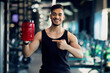 © Prostock-studio - Smiling Sporty Arab Guy Advertising Fitness Supplements While Posing At Gym Interior, Handsome Young Middle Eastern Male Athlete Holding And Pointing At Red Container With Whey Protein Powder