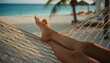 © DisignUA - Close up of tanned legs resting in a woven hammock overlooking the turquoise ocean and white sand