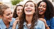 © Lena - A young woman with braces laughs with her friends outdoors in bright sunlight.