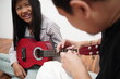 © airdone - Asian father teaching his young daughter how to play the ukulele at home
