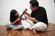 © airdone - Asian father teaching his young daughter how to play the ukulele at home