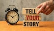 © Onetrick  - Tell your story symbol. Wooden blocks with words Tell your story. Businessman hand. Beautiful grey background with alarm clock. Business and Tell your story concept