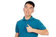 © fotolite - An Asian teenager smiles broadly while giving a thumbs up gesture, wearing a teal polo shirt against a white background, perfect for approval, satisfaction, or positive endorsement concepts.