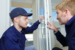 © auremar - insulated door installer and his apprentice