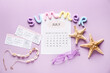 © Pixel-Shot - Calendar with word SUMMER, tickets and beach decor on lilac background. Vacation concept