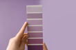 © Pixel-Shot - Female hands with violet paint palette swatches on lilac background
