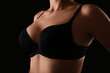 © Pixel-Shot - Young woman in bra on black background, closeup