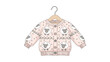 © Safia - Adorable pink knitted baby cardigan featuring a cute sheep pattern is shown hanging on a small wooden clothes hanger for a nursery theme.