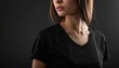 © krisna - Close-up portrait of a young woman wearing a black t-shirt against a dark background with a neutral mood.