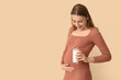 © Pixel-Shot - Young pregnant woman with milk on beige background