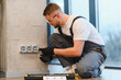 © Serhii - Electrician installing new power outlets in home