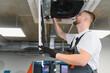 © Serhii - Hvac technician working on ceiling air conditioning unit
