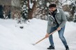 © standret - Man with curly hair wearing a gray jacket and blue jeans is shoveling snow in a winter landscape with trees and a path visible in the background during a snowy day