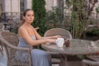 © svetograph - Woman Coffee Cafe - A woman sits at a table in an outdoor cafe, enjoying a cup of coffee.