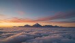 © Joun - A breathtaking aerial view of snow-capped mountains rising above a sea of clouds at sunrise