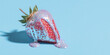 © ALL YOU NEED studio - surreal kitsch product shot featuring a metallic chrome strawberry dripping with iridescent holographic glitter glaze centered against a solid pastel blue background.