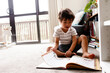 © NZstockphoto - Boy reading book at home on the floor
