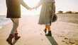 © maxbelchenko - A stylish young couple strolls together along the beach at sunset. The young woman and man enjoy the freedom of the seascape in the sun's rays. Conceptual images of love, nature, and relaxation.