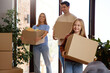 © Valerii Apetroaiei - Happy family moving into new home carrying cardboard boxes