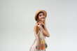 © Volodymyr_sh - Happy young woman with reusable mesh bag full of fresh vegetables posing on light background, eco shopping concept