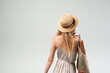 © Volodymyr_sh - Back view of young woman in summer dress holding reusable mesh bag with fresh vegetables, eco shopping concept
