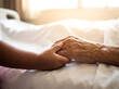 © Aurora Aesthetics - Little african american boy holding grandmother hand in hospital bed close up family support love generation bridge healthcare background copy space hope
