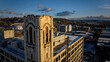 © AmazingAerialAgency - Aerial view of the striking tower casting long shadows across industrial rooftops, a dance of light and form in the urban expanse, Cincinnati, Ohio, United States.