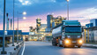 © Bonsales - Tanker truck driving on road, transporting chemicals to industrial refinery plant at sunset, energy infrastructure