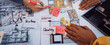 © InfiniteFlow - A dynamic workspace image showcasing hands engaged in a creative collaborative design process with colorful notes and architectural sketches for improved project outcomes. SACTR