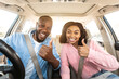 © Prostock-studio - Portrait Of Excited African Amercan Couple Showing Thumbs Up Sign Gesture, Sitting In New Automobile Buying Modern Vehicle In Dealership Store Or Enjoying Vacation. Selective Focus