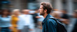© perfectlab - Young man with backpack walking through busy urban street with blurred crowd in background, side profile portrait in casual denim jacket