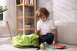 © New Africa - Boy packing his backpack for school at home. Space for text