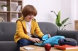 © New Africa - Boy packing his backpack for school on sofa at home. Space for text