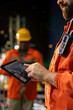 © DC Studio - Close up of offshore platform engineer checking equipment status indicators on tablet system dashboard. Worker verifying hydraulic pressure levels on device digital monitoring panel app