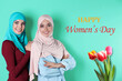 © New Africa - Happy Women's day celebration. Smiling muslim friends in hijabs and bouquet of tulips on turquoise background