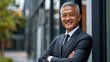 © rak - a beaming mature businessman stands confidently outdoors, radiating professional warmth and approachability against a modern building