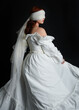 © faestock - close up portrait beautiful female model wearing antique white historical ghost bride wedding dress gown, a veiled mask blindfold covering face. isolated figure on dark studio background, hand gesture