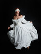 © faestock - full length portrait beautiful female model wearing antique white historical ghost bride wedding dress gown, veiled mask blindfold covering face. isolated walking figure on dark studio background.